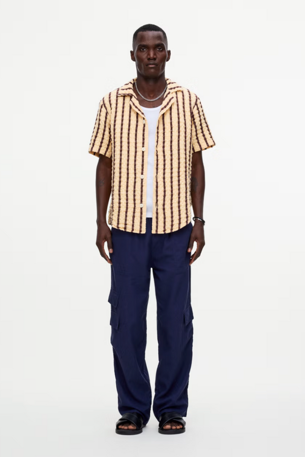 Man wearing a striped shirt and blue pants on a white background