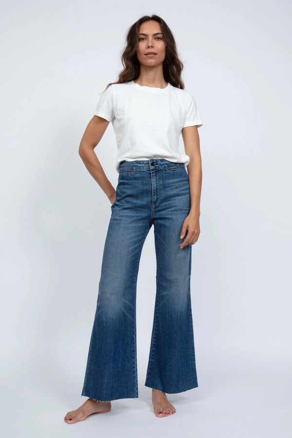 Woman wearing a white t-shirt and blue jeans on a white background