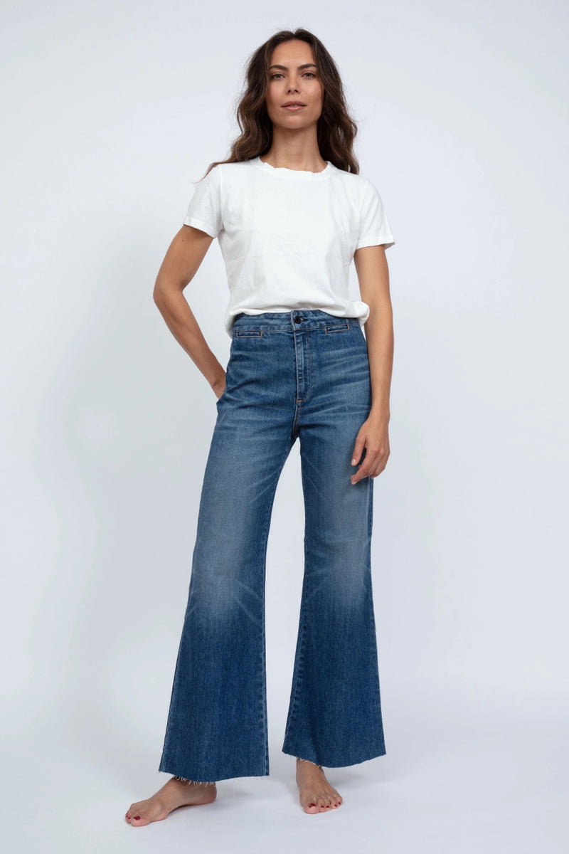 Woman wearing a white t-shirt and blue jeans on a white background