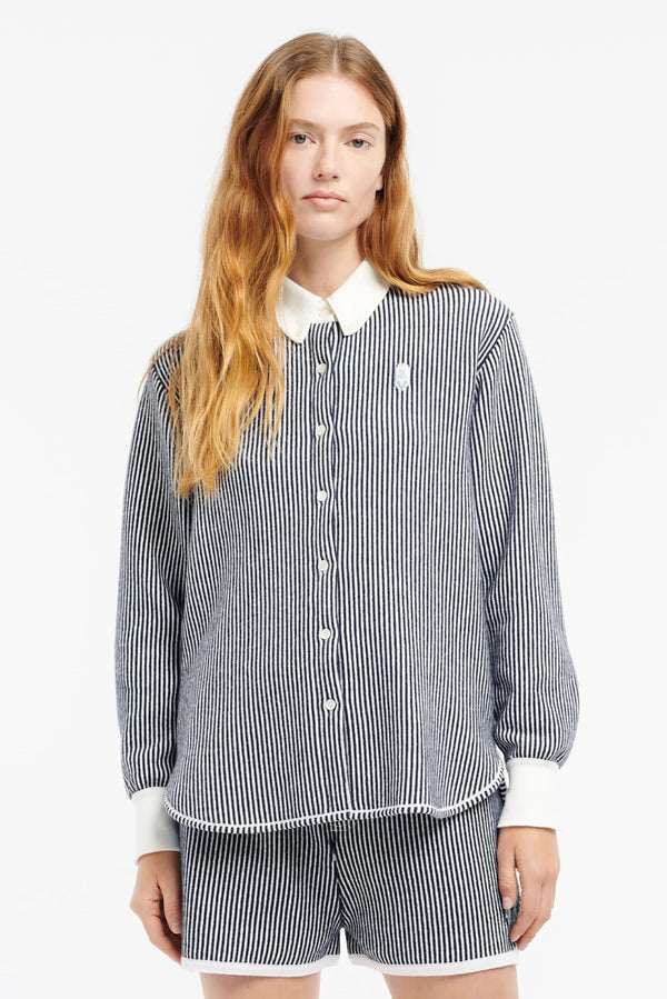 Woman wearing a black and white striped shirt and shorts on a white background