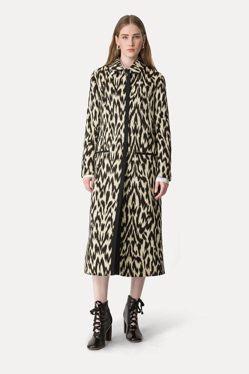 Woman wearing a leopard print coat on a white background